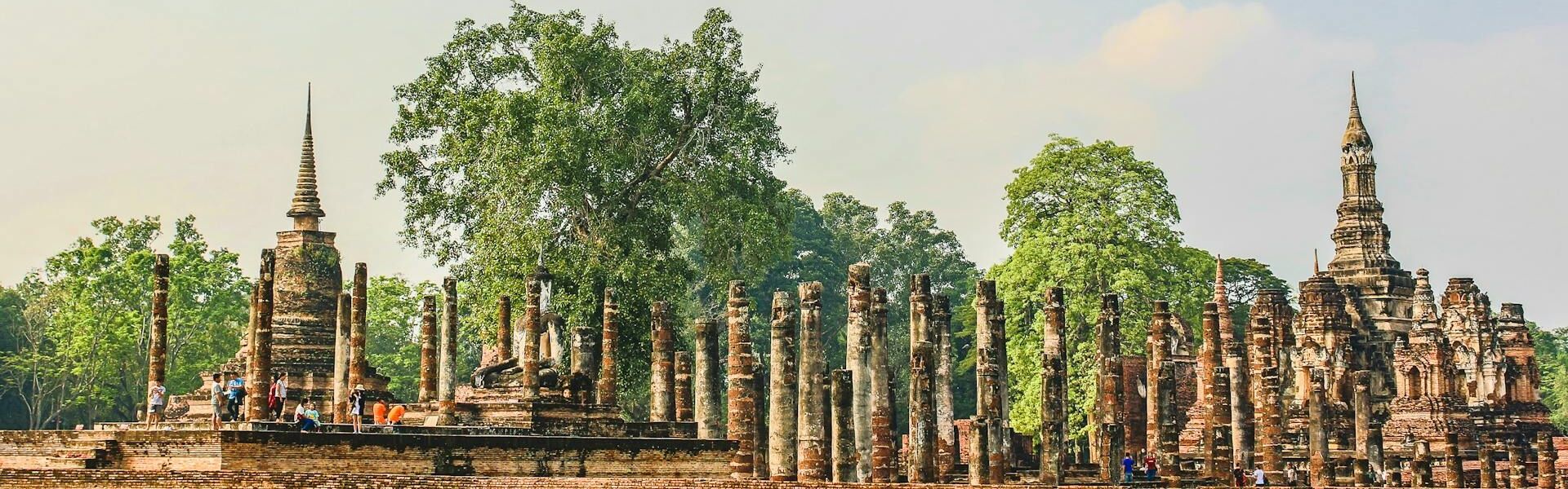 Serene Sukhothai temple ruins in Thailand on a Sukhothai Travel guide banner by Legend Travel Group.